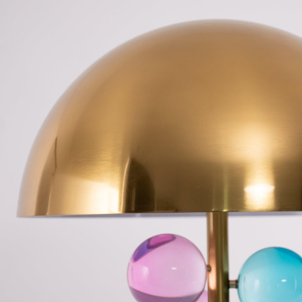 Glass spheres clustered on a gold stem over a marble base