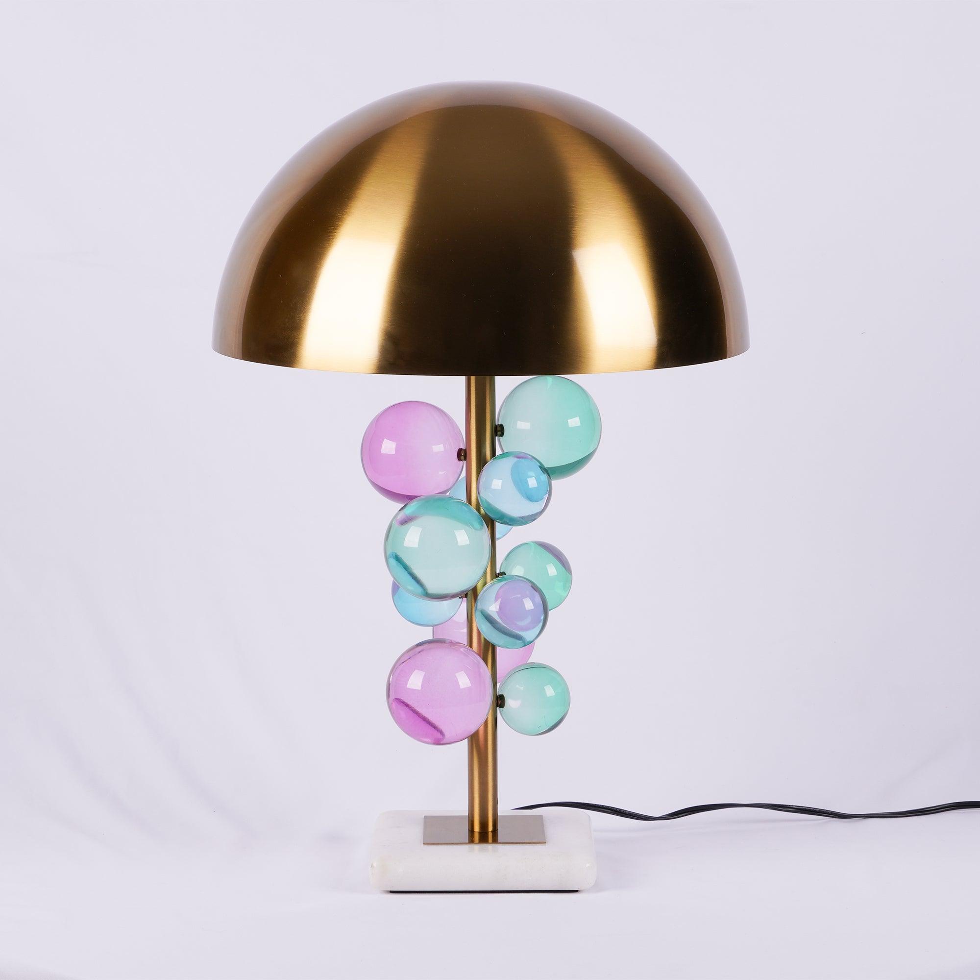 Globo table lamp with gold stem and marble base on a shelf