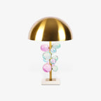 Globo table lamp with gold stem styled in a bright room