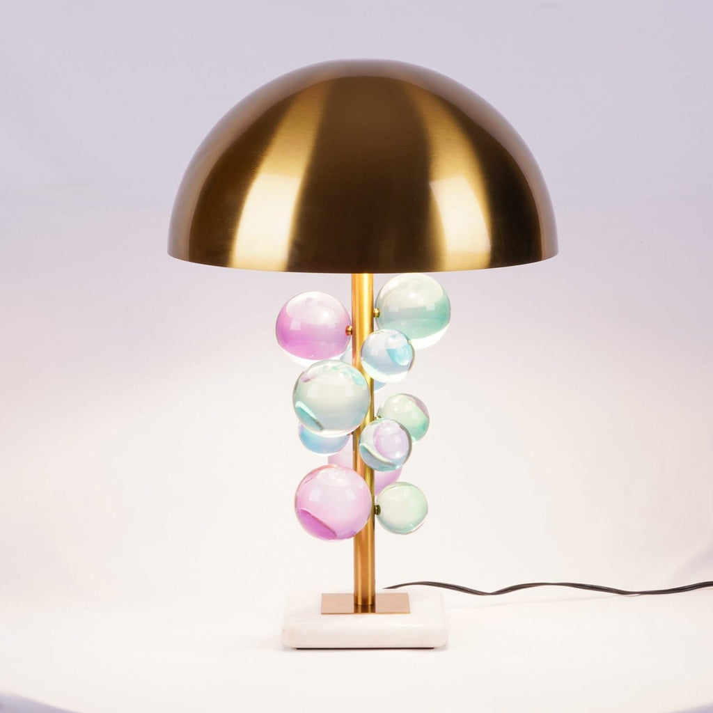 Glass sphere lamp lit beside seating in a warm interior