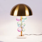 Glass sphere lamp lit beside seating in a warm interior