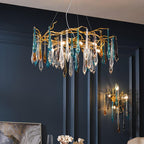 The chandelier lit above a navy panelled dining wall, with the matching wall sconce glowing to its right.