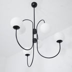 Gooseneck chandelier suspended over a warm dining setting