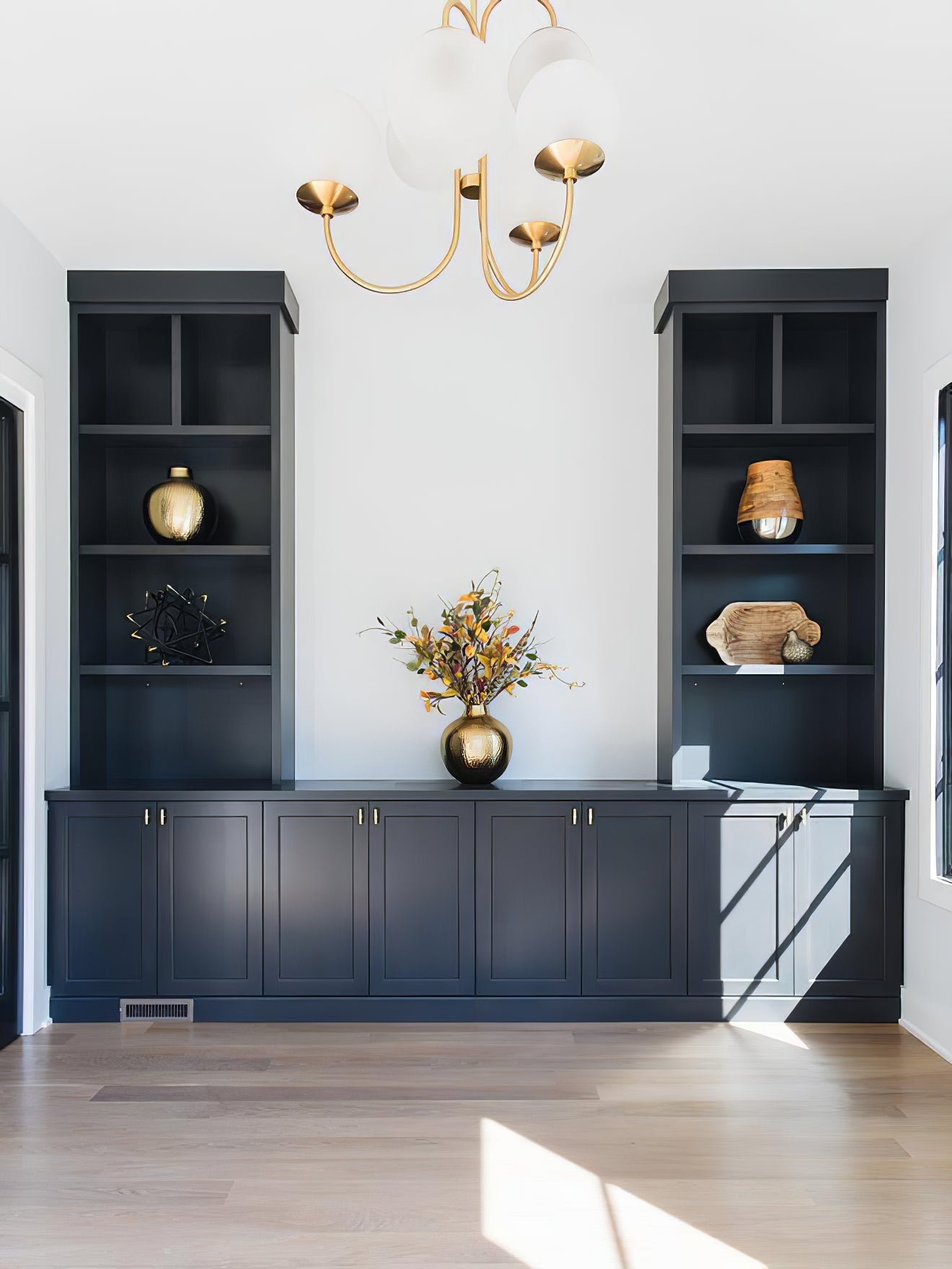 Gooseneck chandelier with curved arms glowing in a living room
