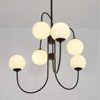 Gooseneck chandelier white glass globes lit in a styled room