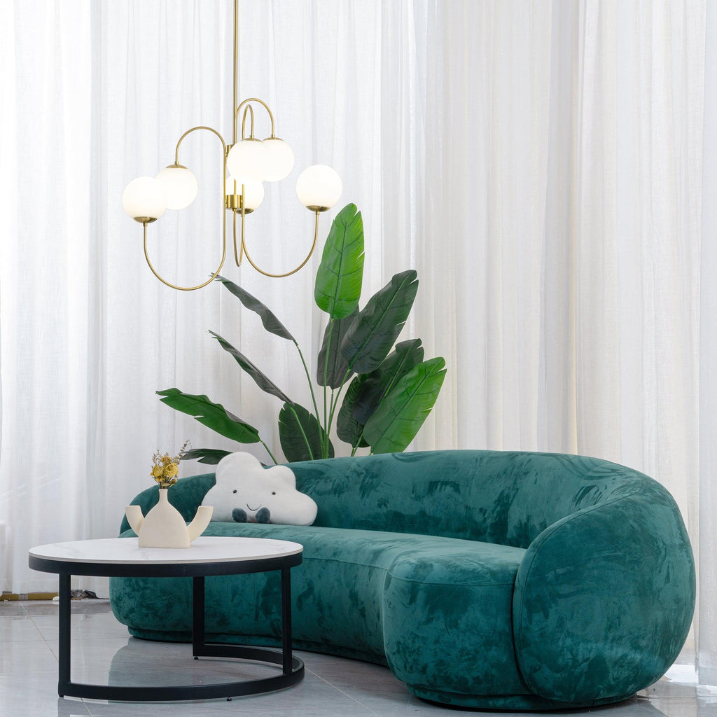 Gooseneck chandelier white glass globes lit over a table
