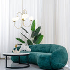 Gooseneck chandelier white glass globes lit over a table