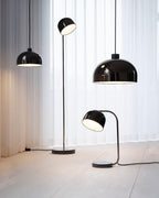 Against sheer white curtains, this black dome-shade Clérachic floor lamp stands with two matching pendant lights.