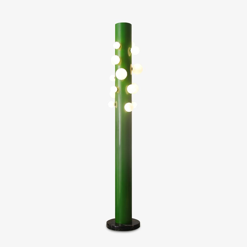 Against plain grey, the green Clérachic floor lamp's tube fades to a darker shade near its base while the globes glow above.