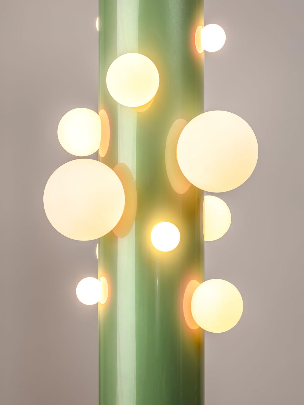 Cropped tightly on plain grey, the green Clérachic floor lamp's frosted glass globes cluster unevenly along its metal tube.