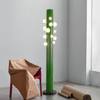 Beside a paper-wrapped chair and a roll of kraft paper, this green Clérachic floor lamp lights a bare concrete-floored corner.