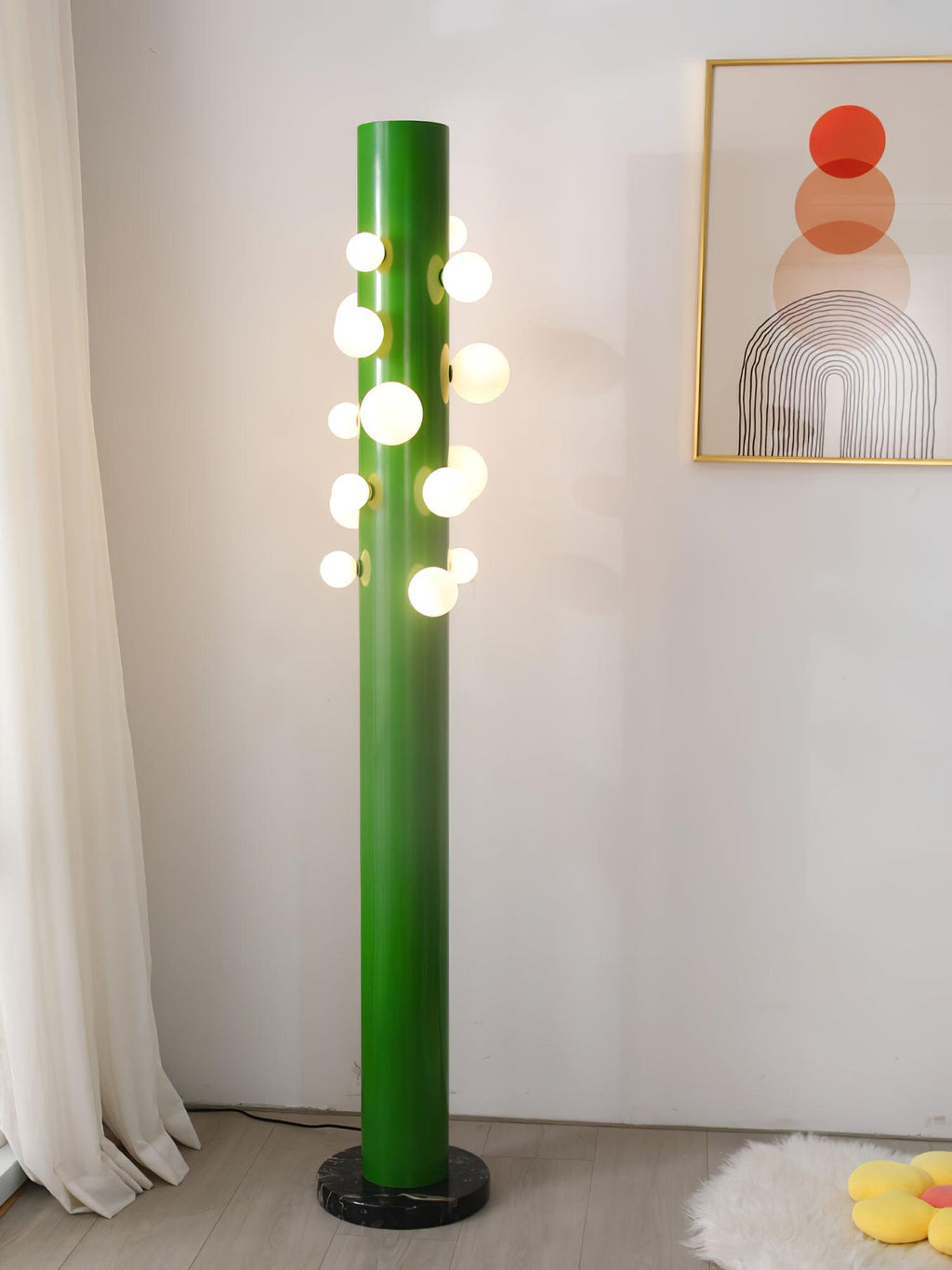 Photographed from a wider angle, the green Clérachic floor lamp still stands on a sheepskin rug near the framed print.