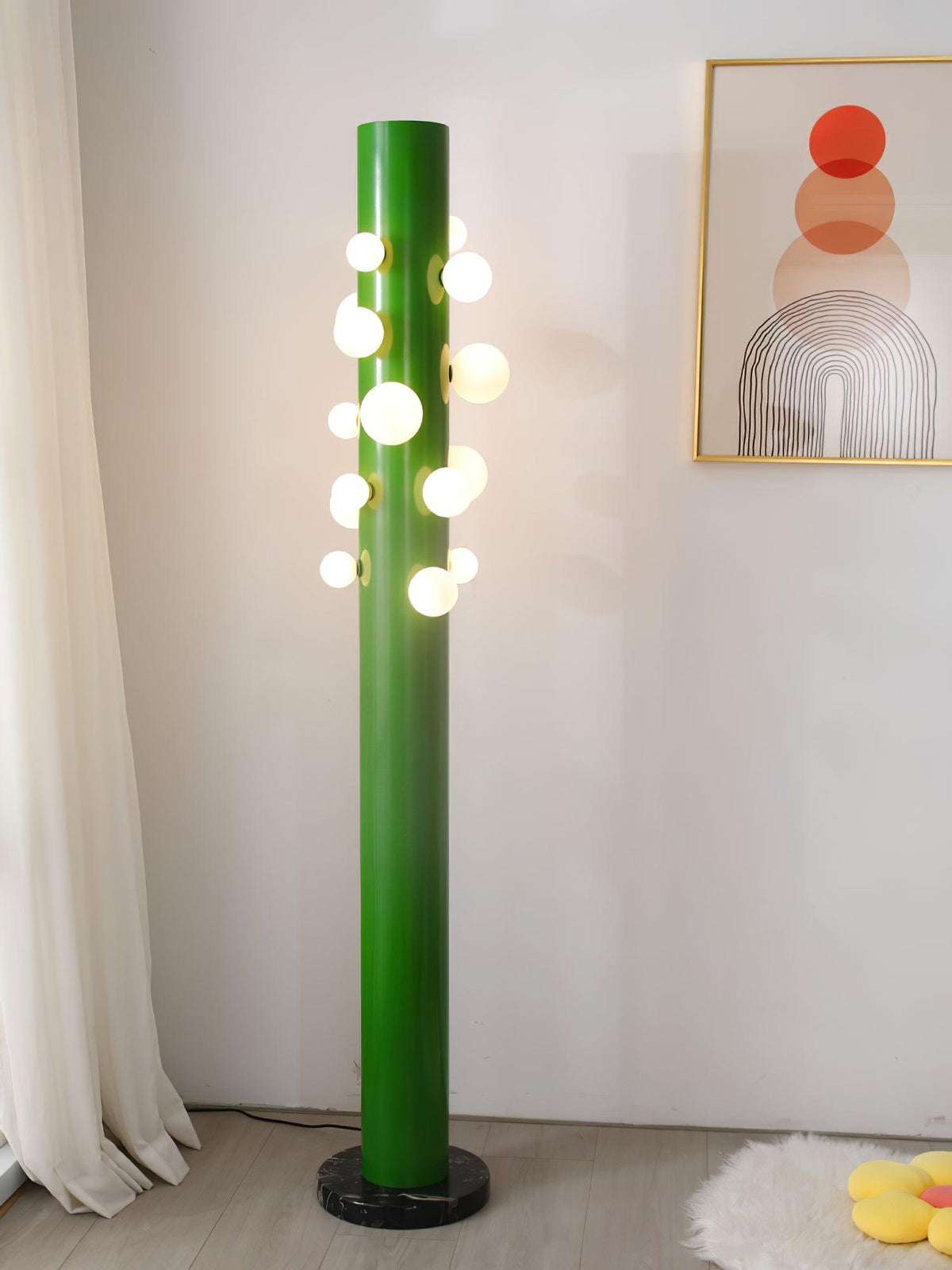 Photographed from a wider angle, the green Clérachic floor lamp still stands on a sheepskin rug near the framed print.