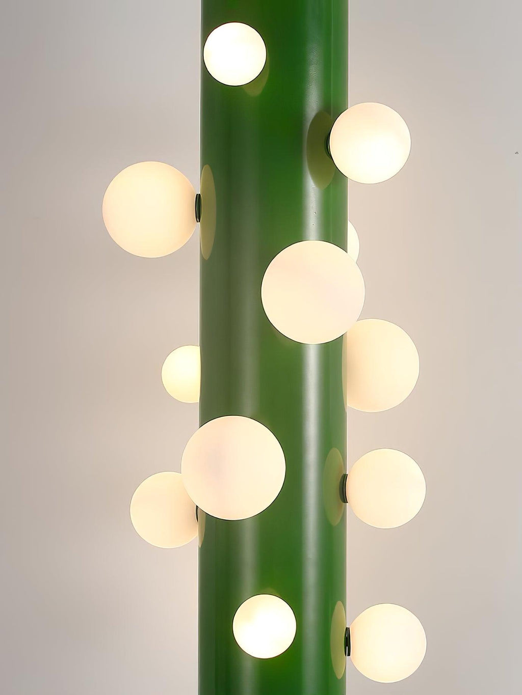 A close-up of the green Clérachic floor lamp shows its cluster of round frosted glass globes in varied sizes along the tube.