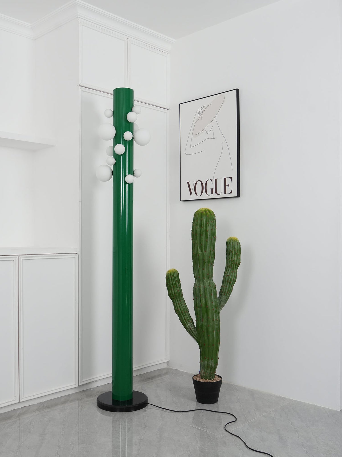 With the cactus in place, the green Clérachic floor lamp's globes appear unlit, plain white against the corner nook.