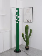 Cropped closer on the base, the unlit green Clérachic floor lamp sits near the potted cactus in the white corner.