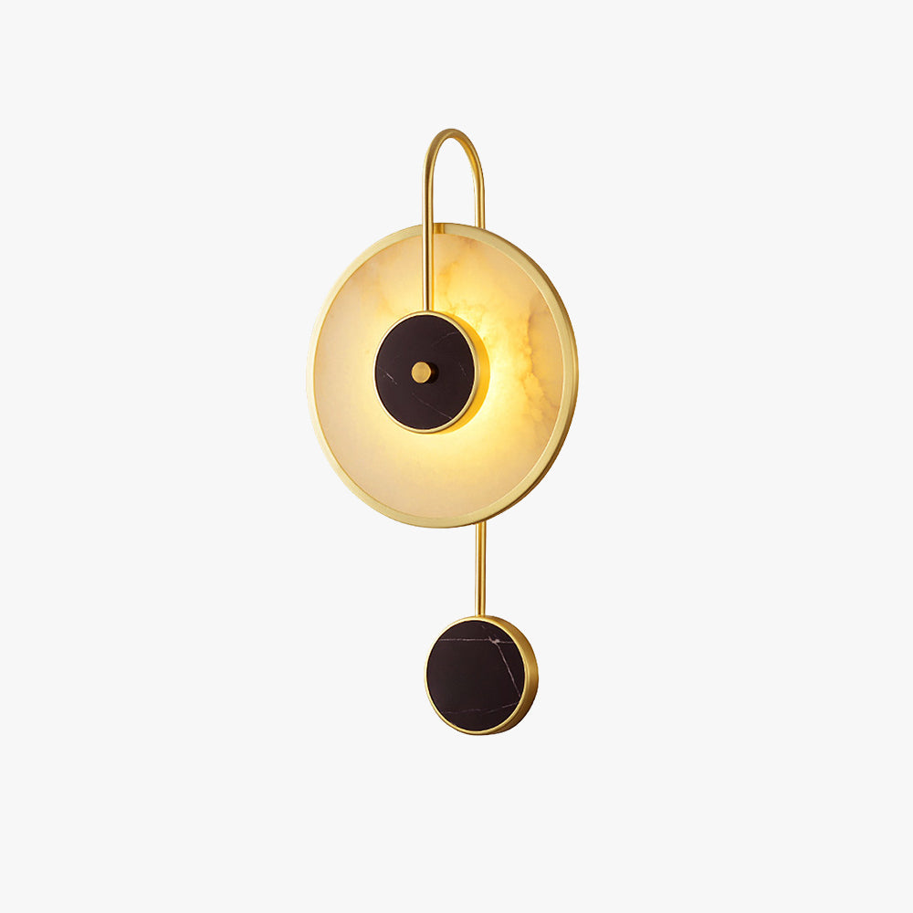 The fixture on white, a brass hook frame holding the alabaster disc above a small black disc.
