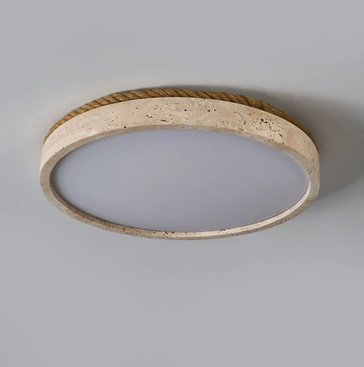 Underside view of this Clérachic flush mount ceiling light, showing the hollow travertine ring and rope trim on a plain background.