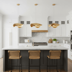 This Clérachic hammered brass trio glows over a dark kitchen island with woven cane stools.