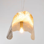Seen from below, this Clérachic shade's lit bulb sits inside its flower-like brass folds.