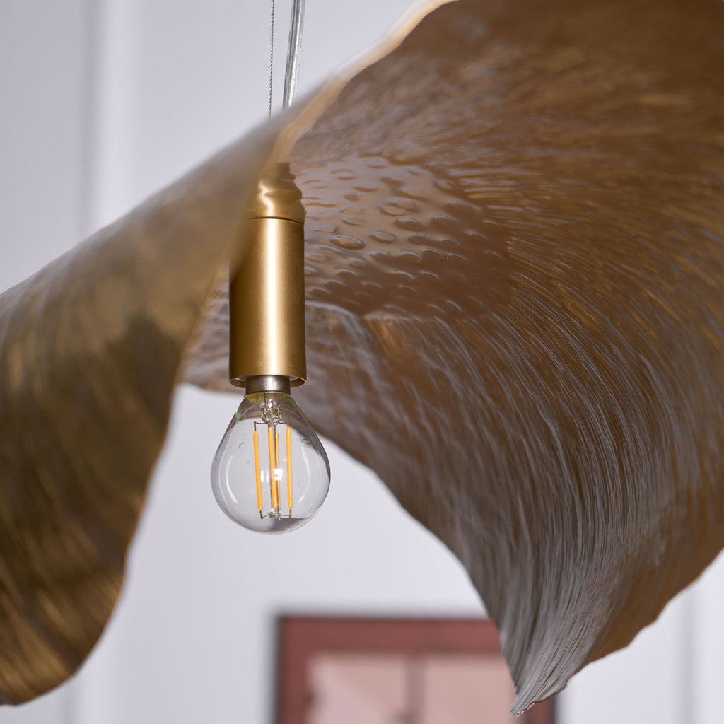 This close view shows the socket, filament bulb and hammered texture of a Clérachic shade from below.