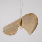Straight-on and lit, this Clérachic hammered brass shade glows gold against plain grey.