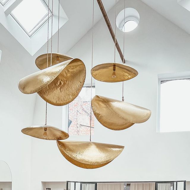 This Clérachic pendant cluster hangs unlit beneath a skylight in a white vaulted ceiling.
