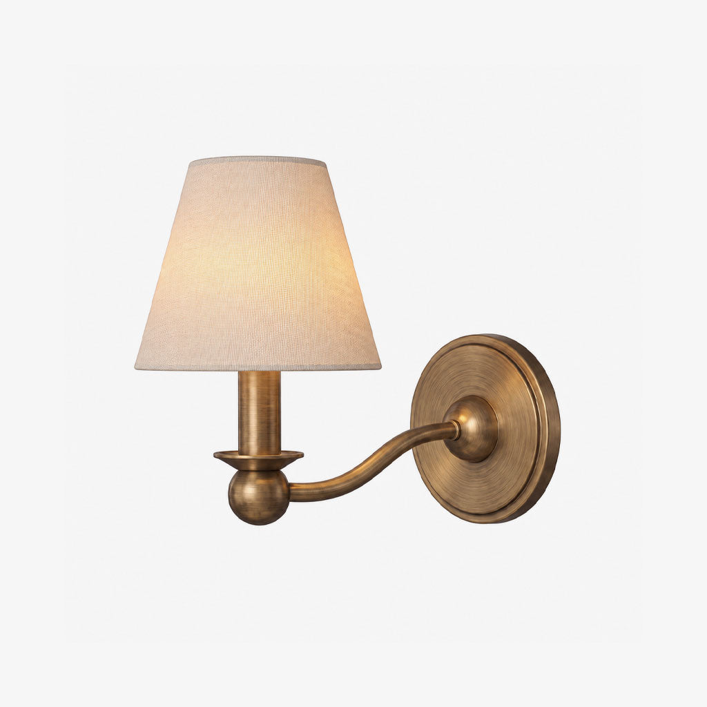 A brushed brass Clérachic wall sconce with one fabric drum shade, photographed unlit on a plain white background.