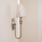Side angle on this Clérachic sconce's U-loop arm in nickel hardware, its alabaster shade set against a plain wall.
