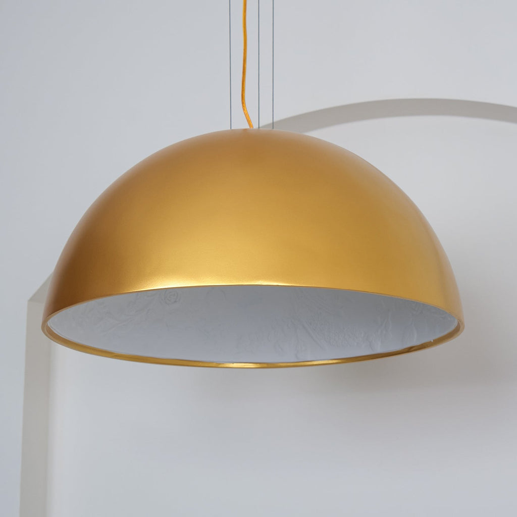 Cast plaster hemisphere pendant lit softly above a surface
