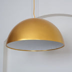 Cast plaster hemisphere pendant lit softly above a surface