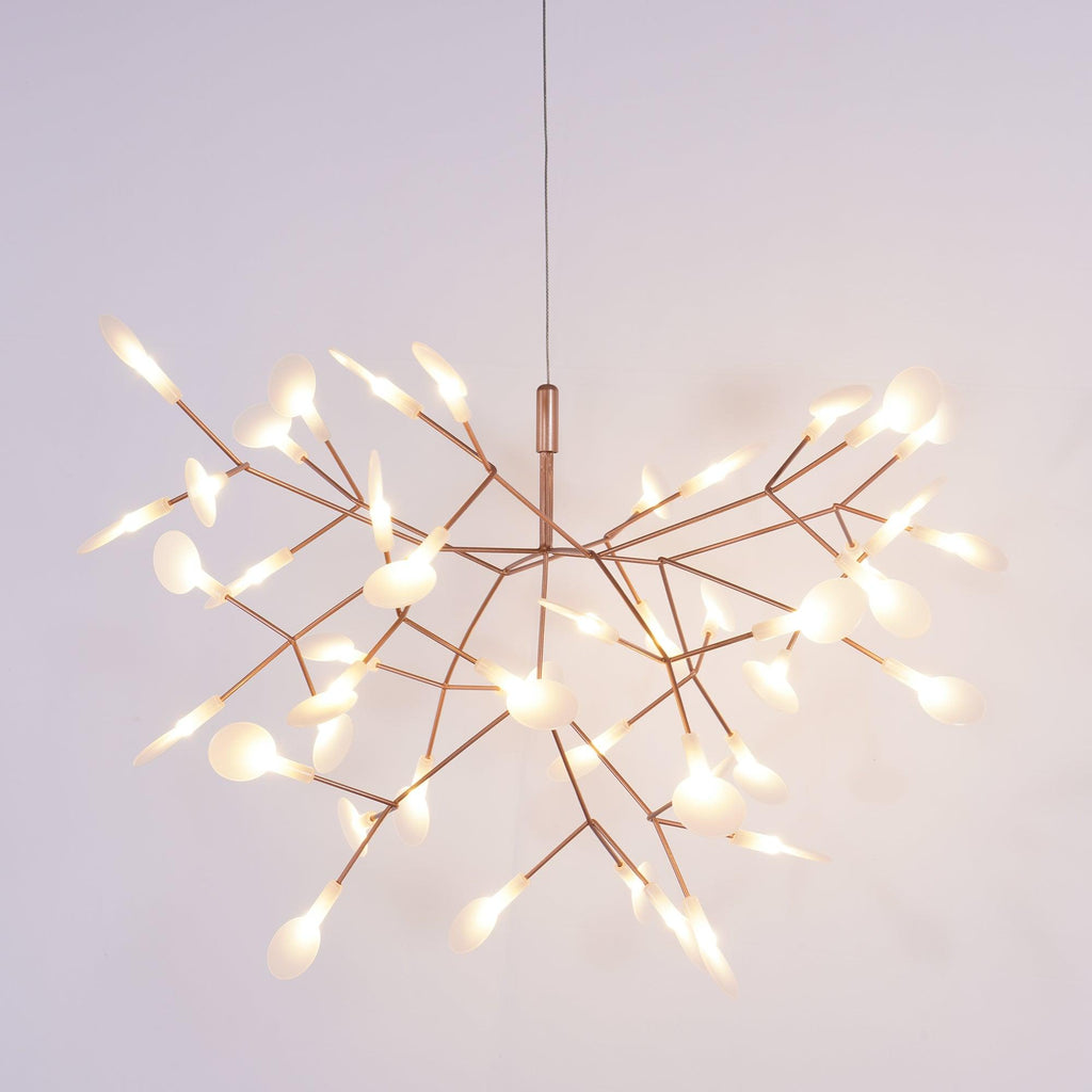 Rose gold firefly chandelier lit as a sculptural centrepiece