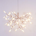Rose gold firefly chandelier lit as a sculptural centrepiece