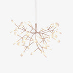 Branching rose gold LED chandelier lit in a dim room
