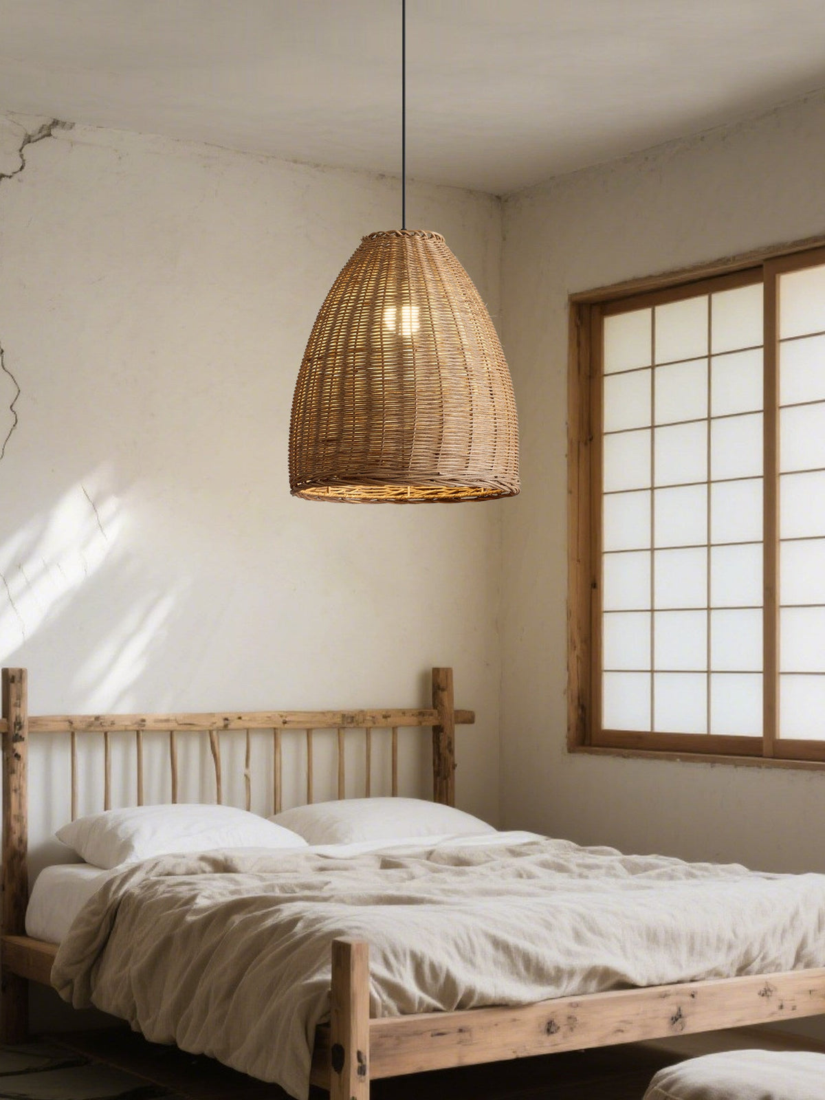 A wood spindle bed frame sits beneath a shoji-style window in a bedroom lit by this rattan Clérachic pendant.