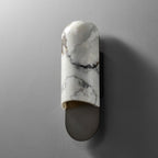 Clérachic marble cylinder wall light photographed straight-on and unlit against a plain grey wall.