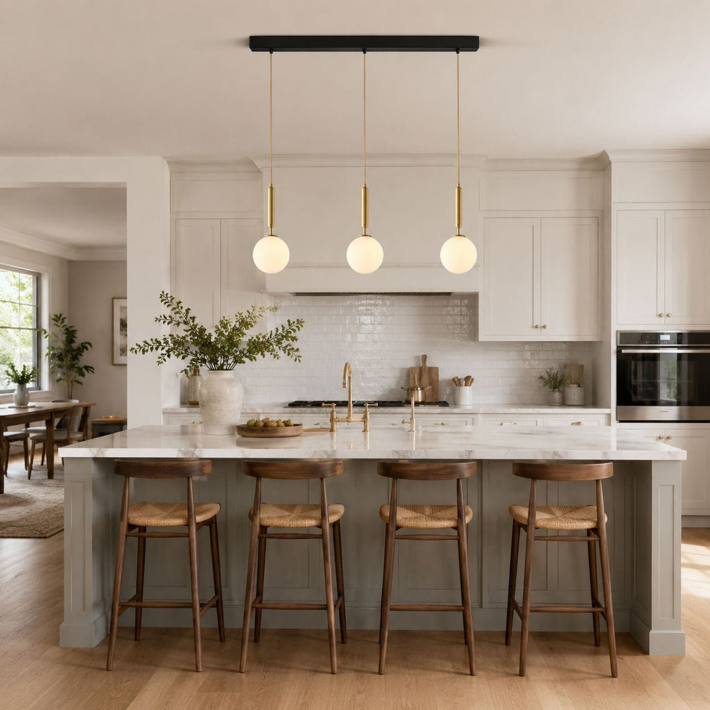 Three Clérachic sphere pendants line a black bar above a kitchen island with grey stools.