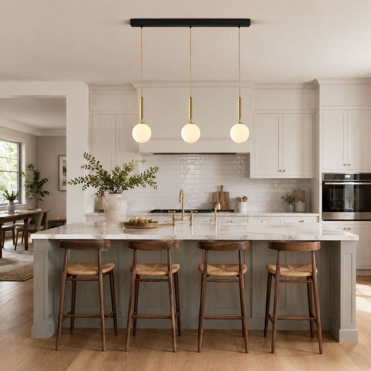 Three Clérachic sphere pendants line a black bar above a kitchen island with grey stools.