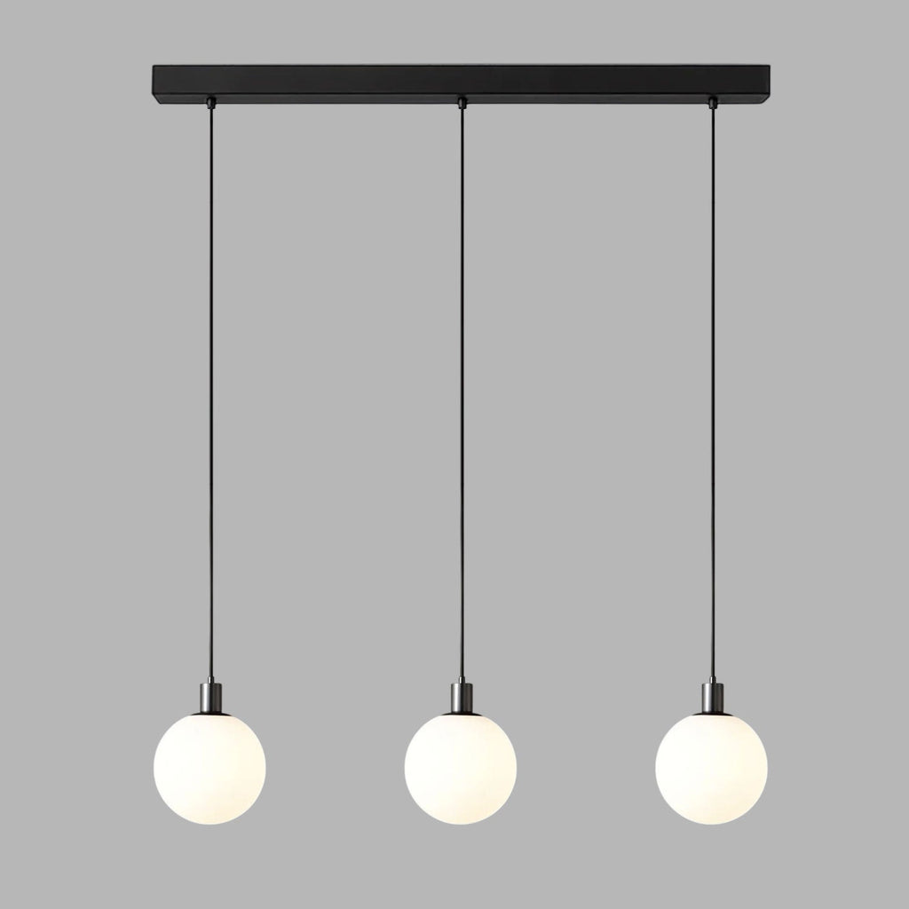 Three black-and-white Clérachic sphere pendants hang from a black bar at staggered heights on grey.