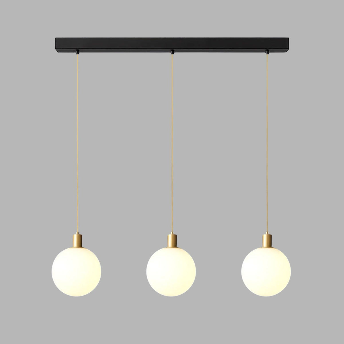 Three brass-and-white Clérachic sphere pendants hang from a black bar against plain grey.