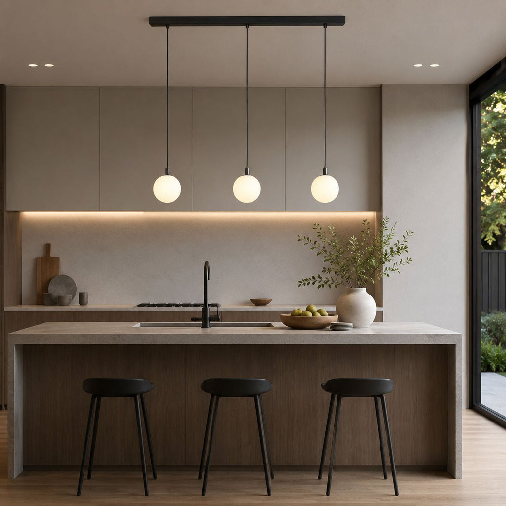 This Clérachic three-head pendant in black and white lights a kitchen island with black stools.