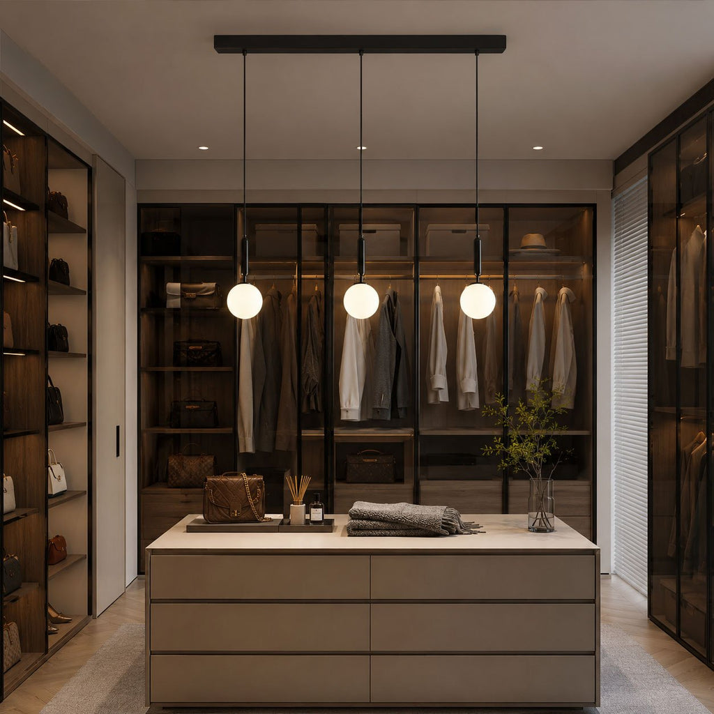 Three black-and-white Clérachic sphere pendants light a walk-in closet with glass-front cabinetry.
