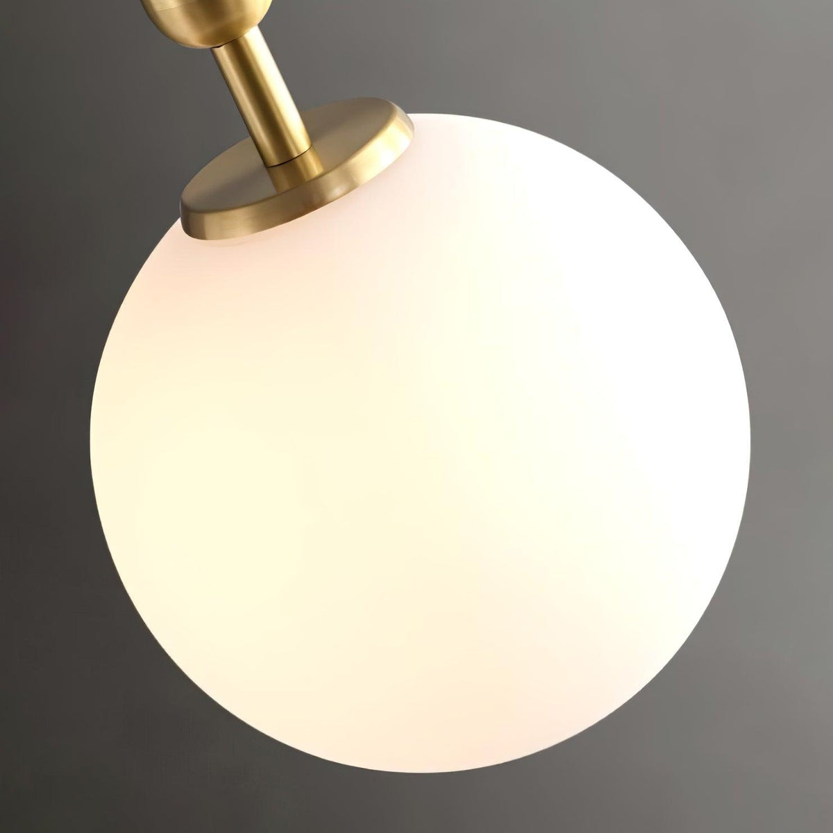 A close view shows the brass fitting and opal glass globe of this Clérachic sphere pendant.
