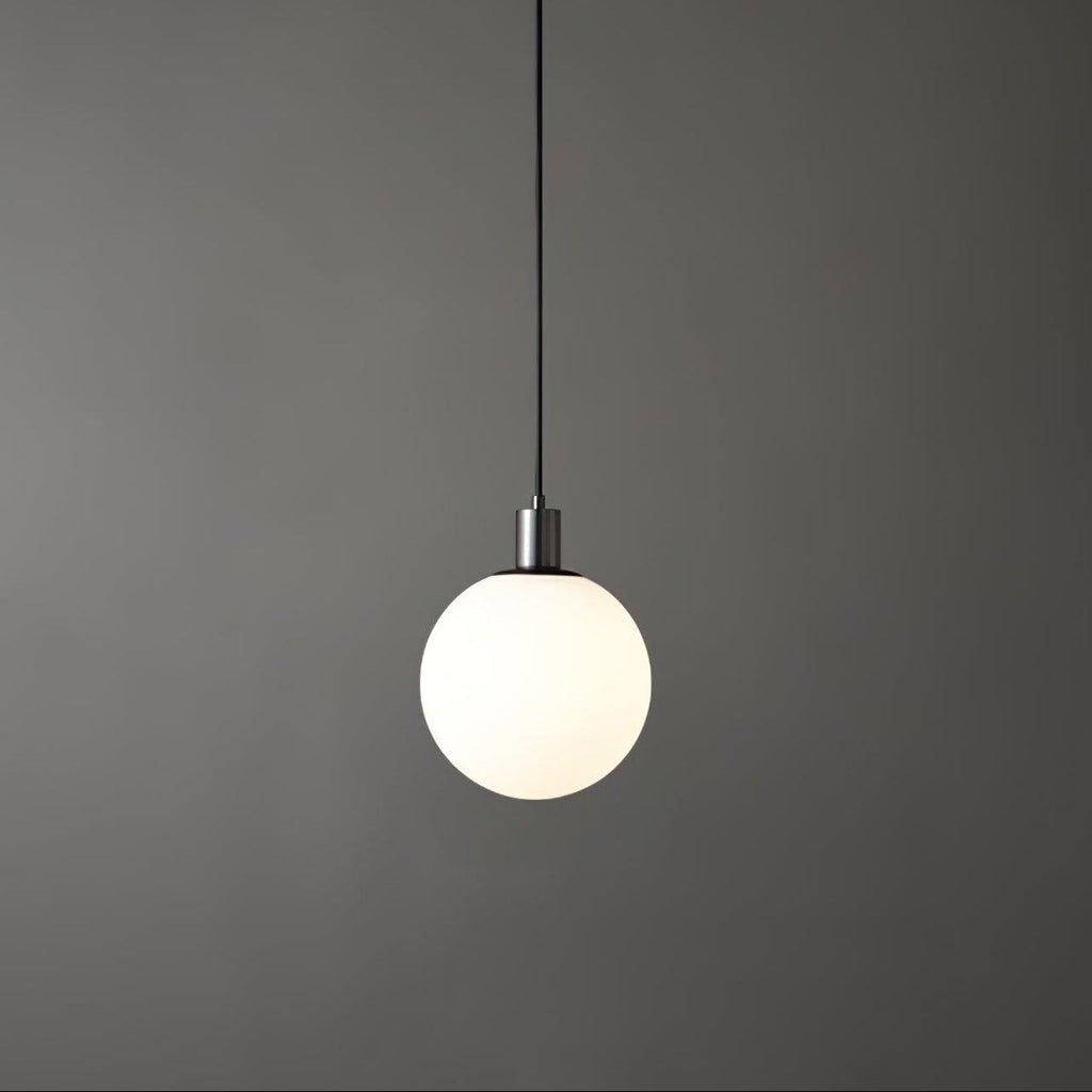 A single black-and-white Clérachic sphere pendant hangs lit against a dark grey backdrop with a plain cord.