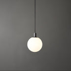 A single black-and-white Clérachic sphere pendant hangs lit against a dark grey backdrop with a plain cord.