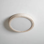 A different angle shows this Clérachic ceiling light unlit, its travertine ring edge lit by soft studio light against grey.