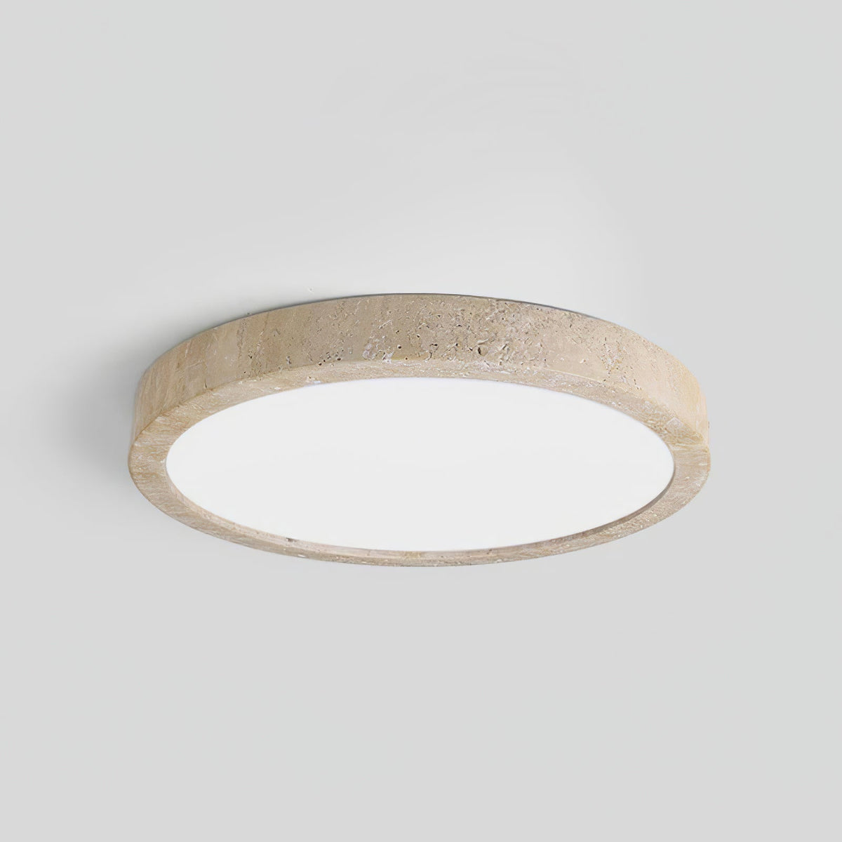 A side profile shows the thickness of this Clérachic ceiling light's travertine ring, against a plain grey background.