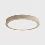 This Clérachic ceiling light is shown at an angle against a plain grey background, its travertine ring catching the light.
