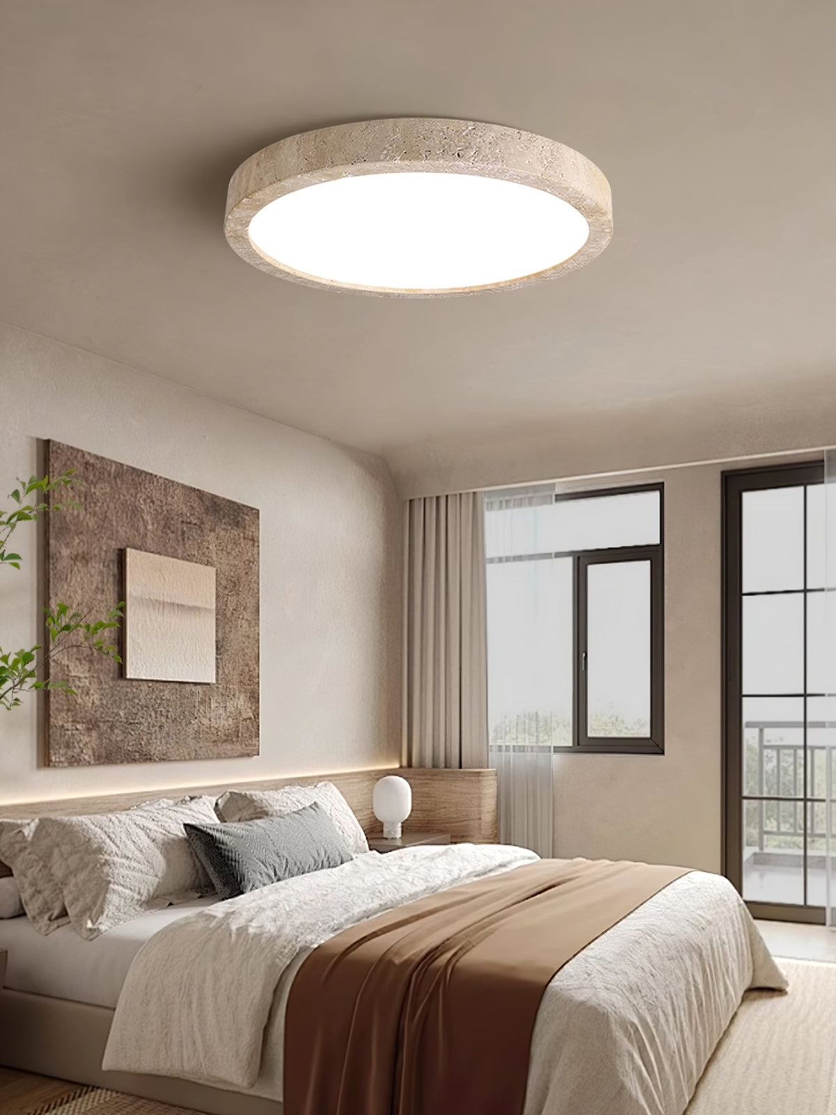 Above a bed dressed with a rust-toned throw, this Clérachic ceiling light sits near a framed stone-textured print and a curtained window.