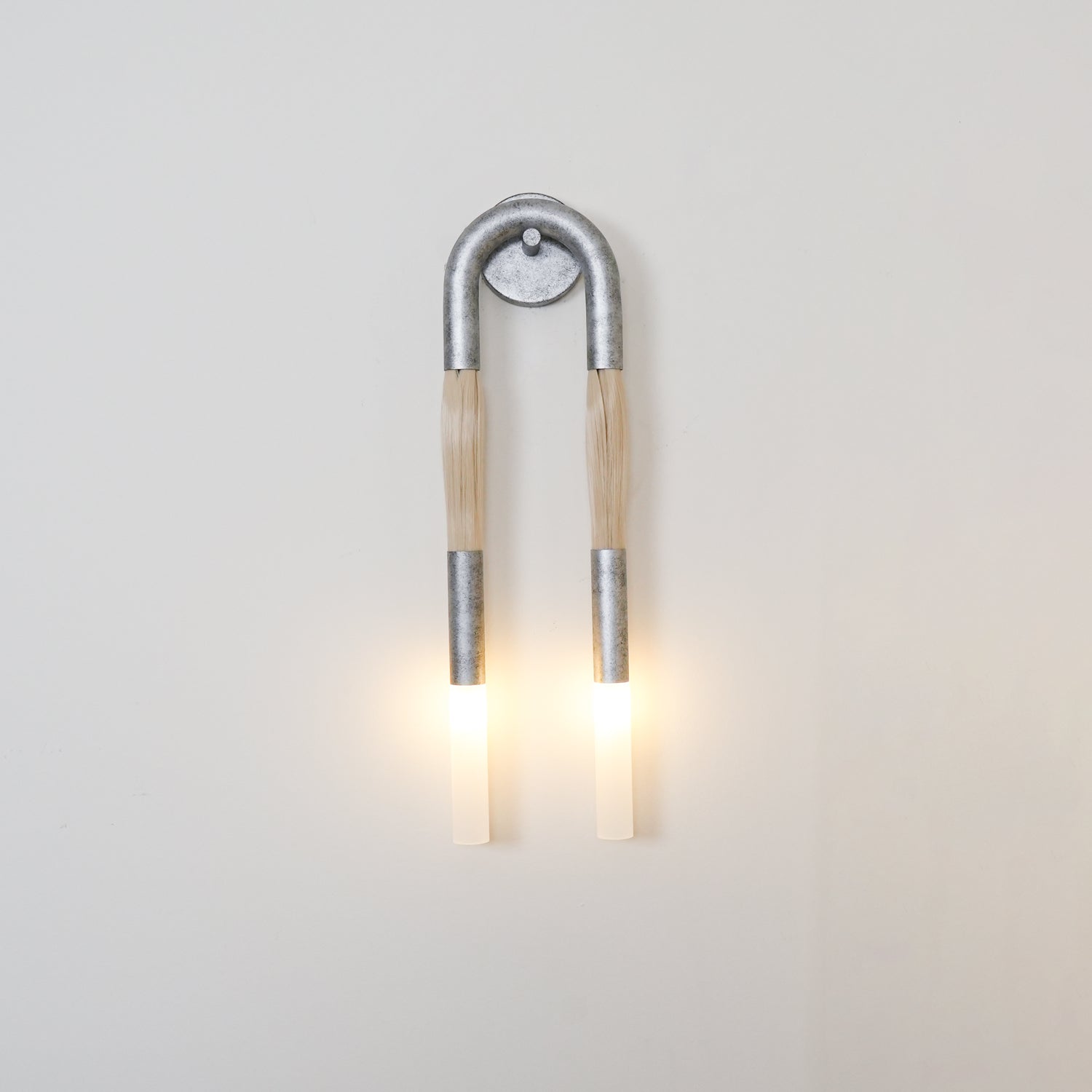 Sculptural horse mane wall lamp glowing in a styled room